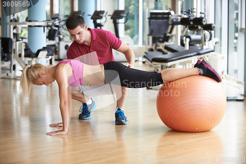 Image of young sporty woman with trainer exercise in fitness gym