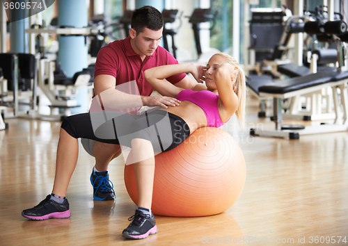 Image of young sporty woman with trainer exercise in fitness gym