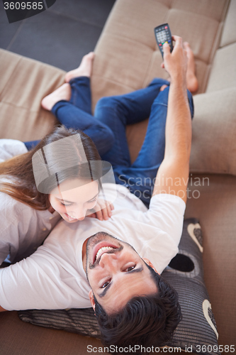 Image of young couple watching tv at home
