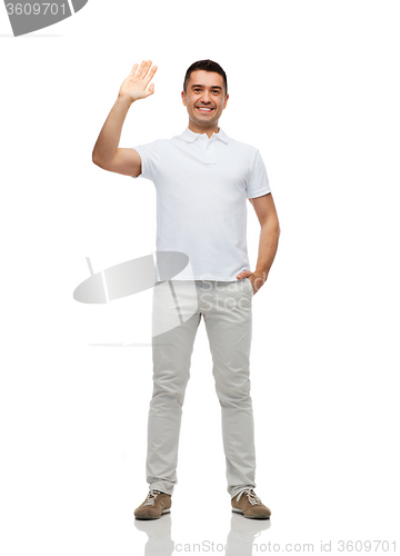 Image of smiling man in blank white t-shirt waving hand