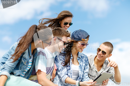 Image of group of teenagers looking at tablet pc computer