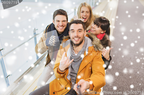 Image of happy friends taking selfie on skating rink