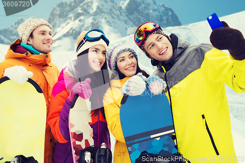 Image of happy friends with snowboards and smartphone