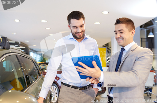 Image of happy man with car dealer in auto show or salon