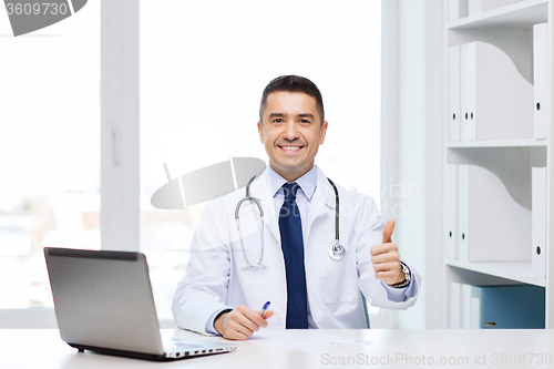 Image of smiling doctor showing thumbs up in medical office