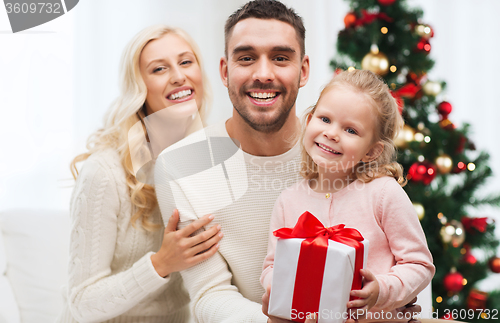 Image of happy family at home with christmas gift box
