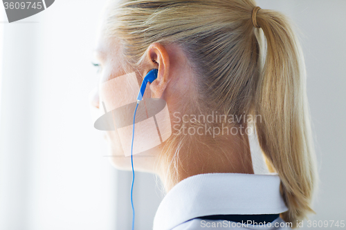 Image of close up of woman in earphones at home