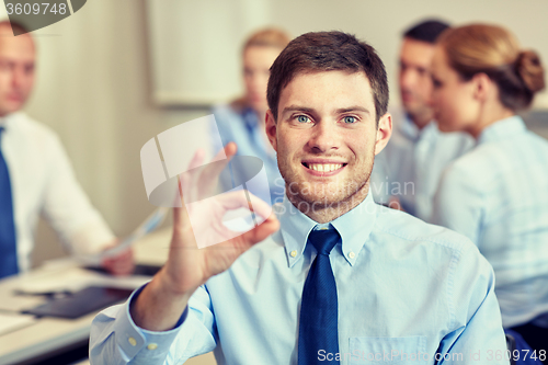 Image of group of smiling businesspeople meeting in office