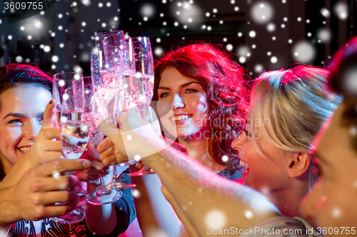 Image of smiling friends with glasses of champagne in club