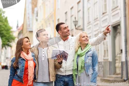 Image of group of friends with city guide exploring town