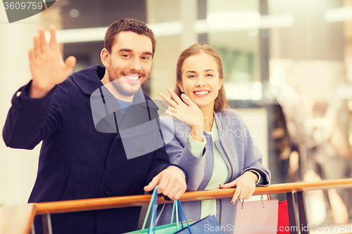 Image of happy young couple with shopping bags in mall