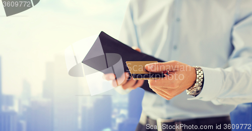 Image of close up of man holding wallet and credit card