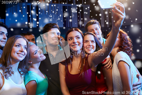 Image of friends with smartphone taking selfie in club