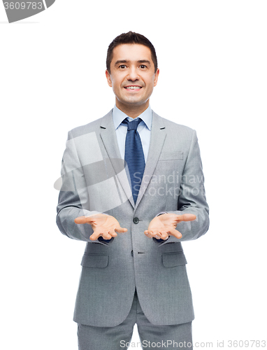 Image of happy businessman in suit showing empty palms