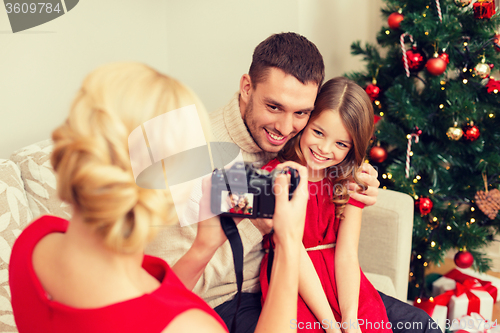 Image of mother taking picture of father and daughter