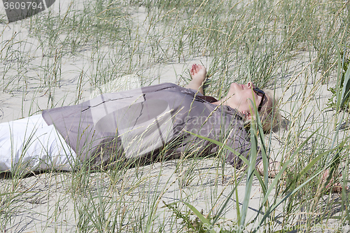 Image of Woman lying in the dunes