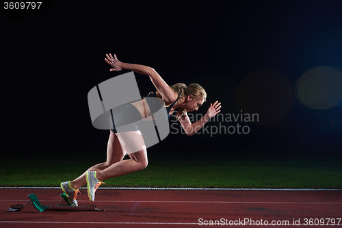 Image of pixelated design of woman  sprinter leaving starting blocks