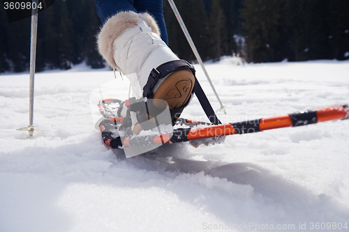 Image of couple having fun and walking in snow shoes