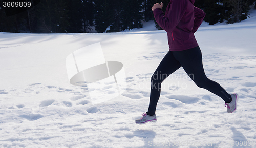 Image of yougn woman jogging outdoor on snow in forest