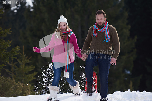 Image of couple having fun and walking in snow shoes