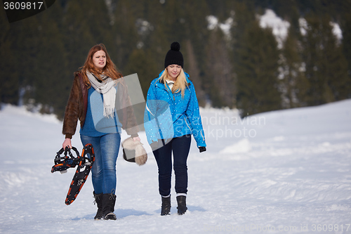 Image of female friends in beautiful winter day have relaxed walk on snow