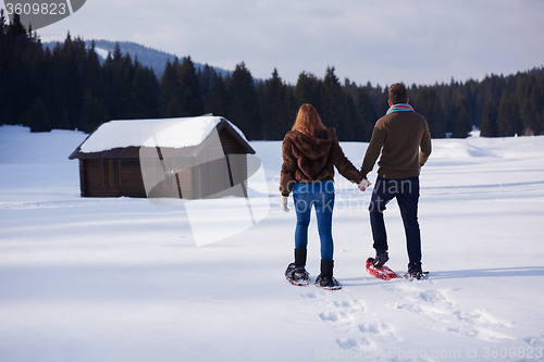 Image of couple having fun and walking in snow shoes