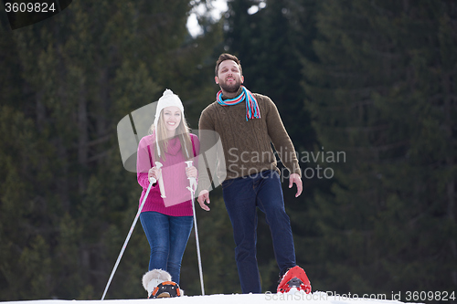 Image of couple having fun and walking in snow shoes