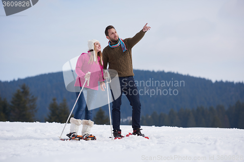 Image of couple having fun and walking in snow shoes