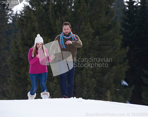 Image of couple having fun and walking in snow shoes