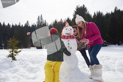 Image of happy family building snowman