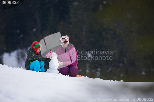 Image of happy family building snowman