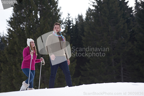 Image of couple having fun and walking in snow shoes