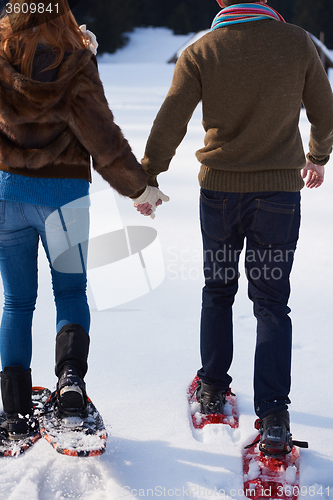 Image of couple having fun and walking in snow shoes