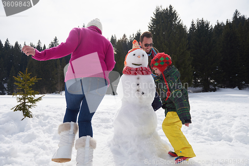 Image of happy family building snowman