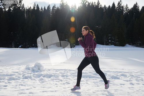 Image of yougn woman jogging outdoor on snow in forest