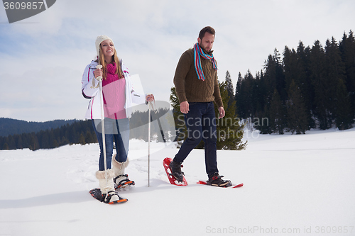 Image of couple having fun and walking in snow shoes