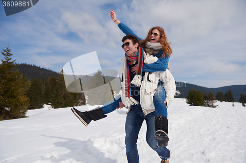 Image of happy young couple having fun on fresh show on winter vacation