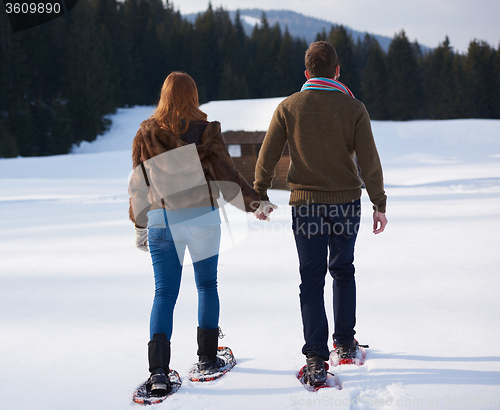 Image of couple having fun and walking in snow shoes