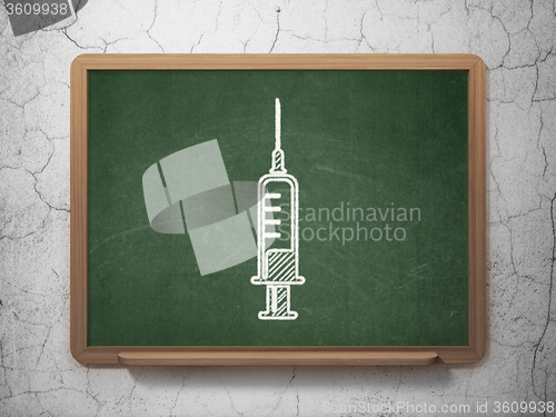 Image of Healthcare concept: Syringe on chalkboard background