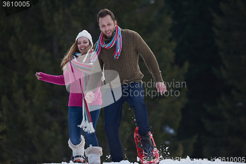 Image of couple having fun and walking in snow shoes