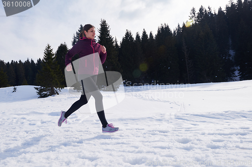 Image of yougn woman jogging outdoor on snow in forest