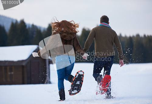 Image of couple having fun and walking in snow shoes