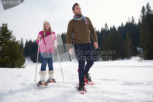 Image of couple having fun and walking in snow shoes