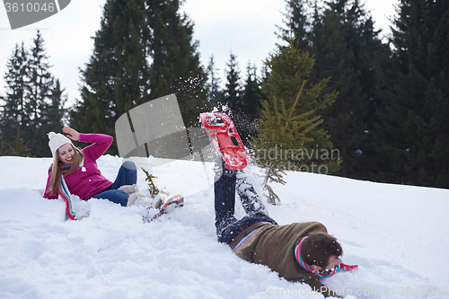 Image of couple having fun and walking in snow shoes