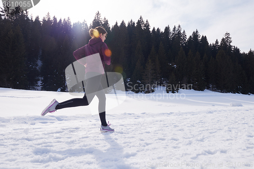 Image of yougn woman jogging outdoor on snow in forest