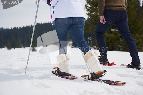 Image of couple having fun and walking in snow shoes