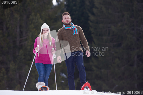 Image of couple having fun and walking in snow shoes