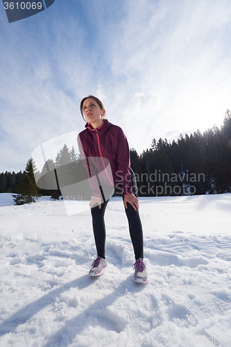 Image of yougn woman jogging outdoor on snow in forest