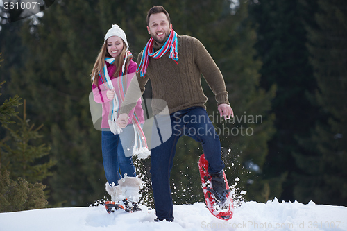 Image of couple having fun and walking in snow shoes