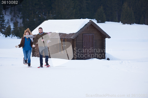 Image of couple having fun and walking in snow shoes